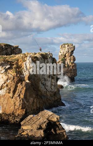 Pêcheurs au sommet des falaises d'Ilheu da Paloa avec des vagues de l'océan Atlantique s'écrasant en contrebas, Peniche, région centrale, Portugal, Europe Banque D'Images