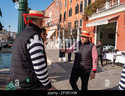 Les gondoliers de San Silvestro discutent avant de commencer les travaux sur le Grand Canal, Venise, Italie. Banque D'Images