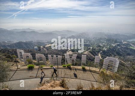 Los Angeles, CA, Etats-Unis, 25 octobre 2013: Une mère et un enfant marchent sur Mount Lee Drive derrière le panneau Hollywood à Los Angeles, CA. Banque D'Images