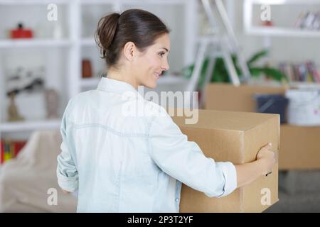 une femme portant une boîte Banque D'Images