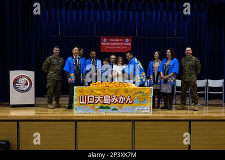 Les membres de l'Association coopérative agricole de la préfecture de Yamaguchi, les dirigeants de la Marine corps Air Station Iwakuni, les étudiants de l'école élémentaire Matthew C. Perry et les invités distingués posent pour une photo lors de la présentation Mikan 2023 au MCAS Iwakuni, Japon, le 19 janvier 2023. La présentation est un événement annuel, au cours duquel les agriculteurs et les distributeurs de l'île Suo-Oshima donnent aux étudiants des mikans, un fruit saisonnier d'hiver et symbole de l'île. Les élèves témoignent de leur appréciation en créant des sacs-cadeaux personnalisés et en offrant un spectacle de la chorale de l’école aux invités distingués Banque D'Images