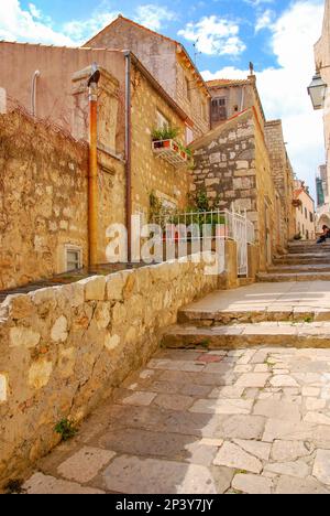 Maisons en pierre le long d'une rue étroite dans la vieille ville de Dubrovnik. Un touriste s'assoit et se détend. Vieille ville. Croatie. Banque D'Images