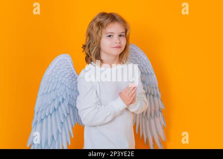 Angel prière enfants. Enfant portant un costume d'ange robe blanche et ailes de plumes. Enfant innocent. Banque D'Images