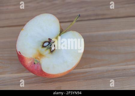 La saveur sucrée et artistique d'une pomme sur une surface en bois. Banque D'Images