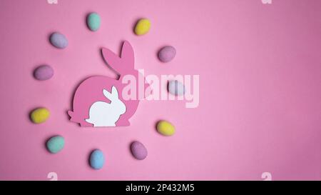 Motif pâques créatif composé d'œufs colorés en couronne avec lapin de pâques sur fond rose. Concept joyeuses Pâques. Flat lay, espace de copie Banque D'Images