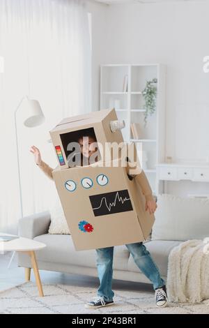 Petit garçon en costume robot en carton jouant à la maison Banque D'Images