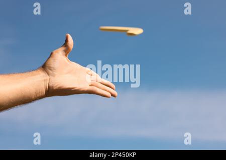 Homme lançant boomerang contre le ciel bleu, gros plan Banque D'Images