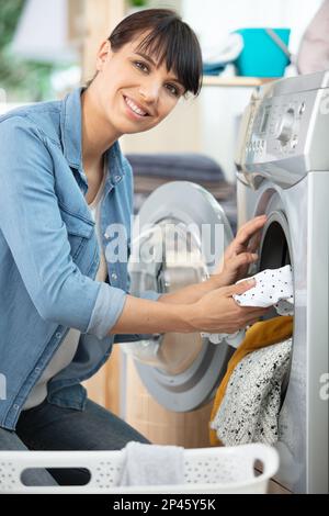 bonne femme vidant un lave-linge Banque D'Images