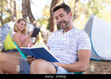 un homme heureux est en train de lire un livre Banque D'Images