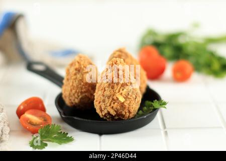 Coxinha Brazilian snack, pâte frite avec garniture de poulet déchiquetée, sur table en bois blanc Banque D'Images