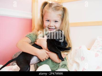 Bonne petite fille du Caucase avec un chiot. Chien de garde d'enfant. Concept PET. Enfant souriant Banque D'Images