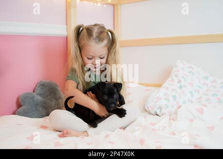 Bonne petite fille du Caucase avec un chiot. Chien de garde d'enfant. Concept PET. Enfant souriant Banque D'Images