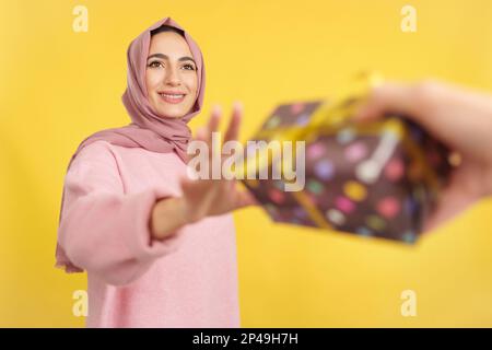 Bonne femme musulmane souriant tout en recevant un cadeau Banque D'Images