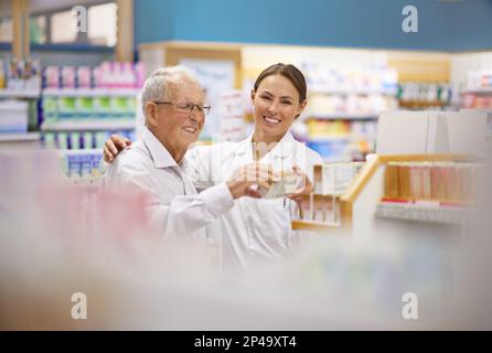 Chaque client est un individu. un jeune pharmacien aidant un client âgé. Banque D'Images