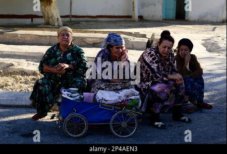 Femmes ouzbèkes vendant du thé d'une vieille voiture de bébé à Boukhara, Ouzbékistan. Banque D'Images