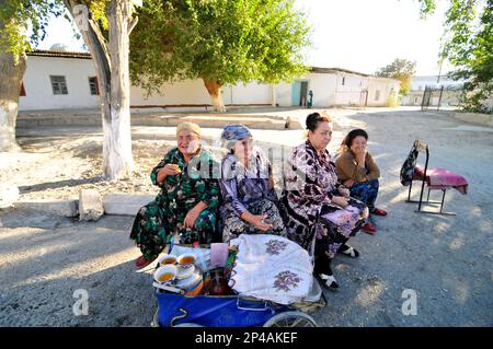 Femmes ouzbèkes vendant du thé d'une vieille voiture de bébé à Boukhara, Ouzbékistan. Banque D'Images