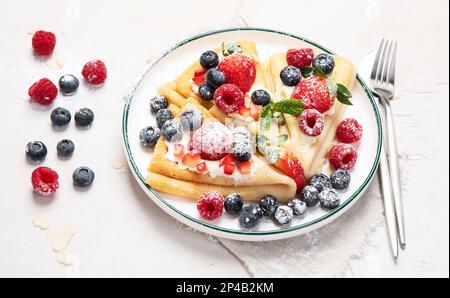 Petit déjeuner sain, crêpes traditionnelles faites maison ou crêpes avec baies fraîches, fond léger le matin. vue de dessus Banque D'Images