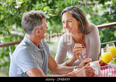 Je ne cesse jamais de vous apprécier. un couple mûr se liant tout en prenant le petit déjeuner ensemble à l'extérieur. Banque D'Images