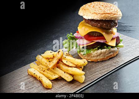 Que feriez-vous de sacri-frites pour ce repas ? un délicieux hamburger à triple étage avec frites. Banque D'Images