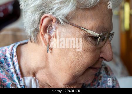 femme portant une prothèse auditive numérique Banque D'Images
