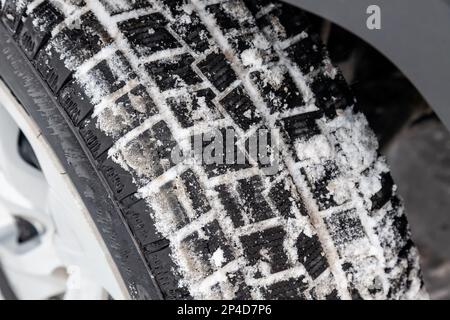 Gros plan sur une roue avec la bande de roulement des pneus à crampons avec peu de porter pendant le tournage pour un accouchement sans risque dans la neige et la glace. Banque D'Images