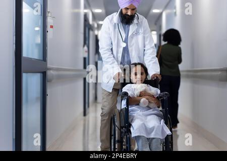 Portrait d'un médecin sikh en marche turban avec une fille en fauteuil roulant à l'hôpital Banque D'Images