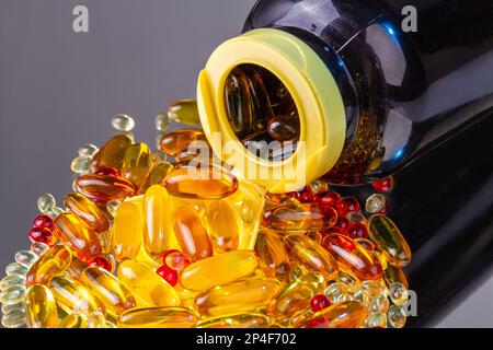 Gros plan sur le flacon renversé avec pile de pilules de vitamine. Capsules de vitamines Omega. Banque D'Images