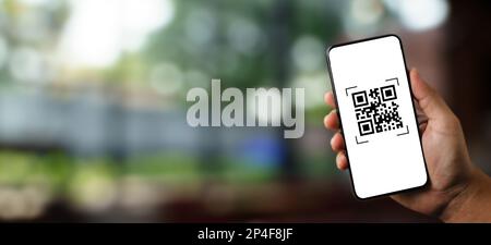 Scannez des codes QR avec une application de téléphonie mobile et payez des biens et des services dans l'arrière-plan du supermarché de détail Banque D'Images