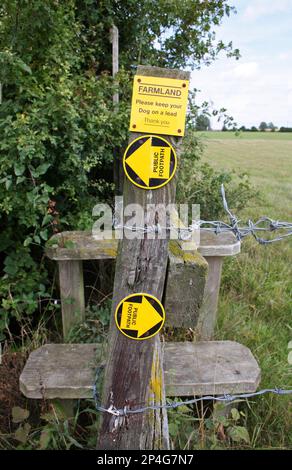 Panneaux « public Footpath » et « Farland », Please Keep your dog on a lead », à côté de la bordure du champ, Haughley, Suffolk, Angleterre, Royaume-Uni Banque D'Images