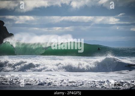 Grande vague avec l'observation des surfeurs à Porth Ceiriad près d'Abersoch Banque D'Images