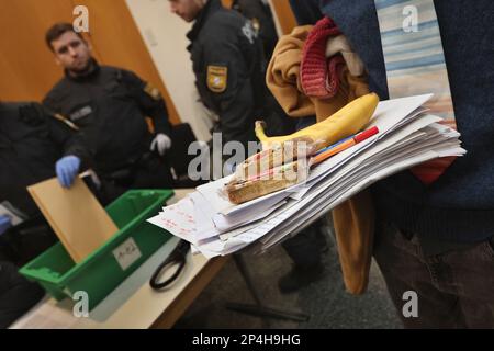 Augsbourg, Allemagne. 06th mars 2023. Un homme de 34 ans se tient devant une salle d'audience du tribunal local pendant le contrôle d'admission avec des documents et des rations. L'homme est accusé d'avoir occupé le gouvernement de la Souabe avec deux autres personnes en octobre 2022, malgré une interdiction d'entrer dans la maison, et d'avoir accusé le président du gouvernement de l'époque de corruption. Credit: Karl-Josef Hildenbrand/dpa/Alay Live News Banque D'Images