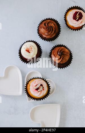 Délicieux chocolats, velours rouge, petits gâteaux à la framboise aux coeurs blancs Banque D'Images