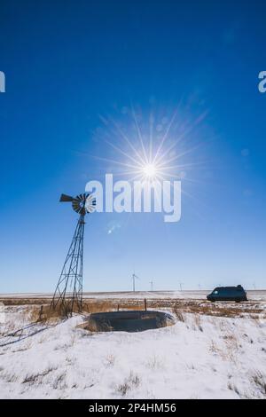 Anciens et nouveaux moulins à vent avec une camionnette garée par une belle journée d'hiver, Kansas Banque D'Images