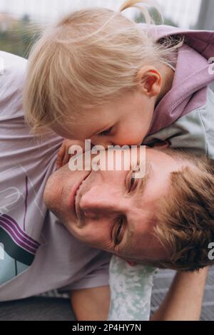 Papa et bébé fille s'amusent près du stade de football Banque D'Images