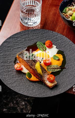 steak de saumon grillé avec sauce dans une assiette sur une table en bois Banque D'Images