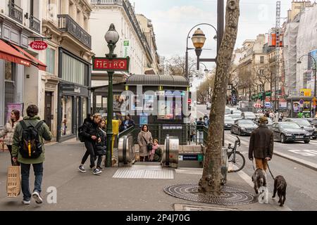 Les gens marchent vers et de et après l'entrée de la station de métro Grand Boulevard sur le boulevard Poissonnière, 2nd arrondissement de Paris. Banque D'Images