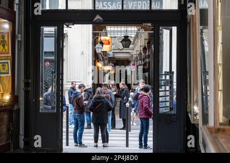 Les gens se tiennent devant le passage Verdeau, tourné en regardant hors du passage Jouffroy dans le 9th arrondissement de Paris. Banque D'Images