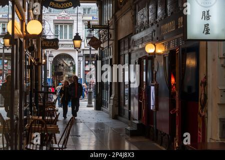 Un couple marchant dans le passage des Panoramas dans le 2nd arrondissement de Paris. Banque D'Images