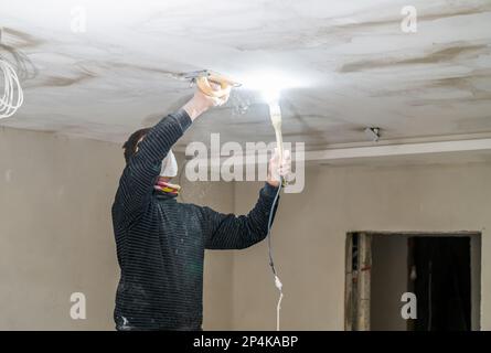 ponçage manuel du plafond en plaques de plâtre avec une truelle Banque D'Images