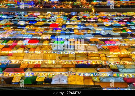 Gros plan de rangées de tentes colorées et de stands de nourriture la nuit. Banque D'Images