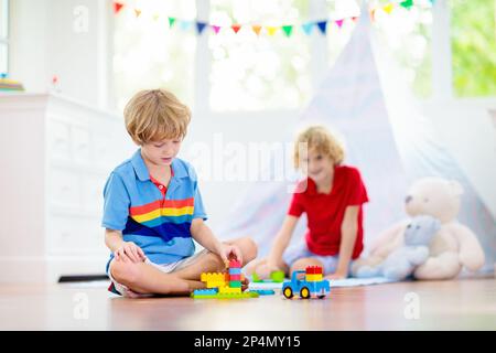 Chambre pour enfants avec tente à tipi. Les enfants jouent dans une chambre blanche ensoleillée. Intérieur lumineux et confortable pour la garderie ou la salle de jeux. Banque D'Images