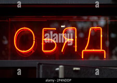 Un panneau au néon rouge au-dessus de la porte ouverte d'un restaurant dit en bulgare « Обяд », signifiant en anglais « déjeuner ». Banque D'Images