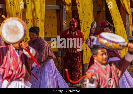 TRONGSA, BHOUTAN - 6 JANVIER 2017 : Jokster regardant des moines répéter la danse des démons dans le Seigneur de la mort au festival Tsechu dans le Trondsa Dzong Banque D'Images