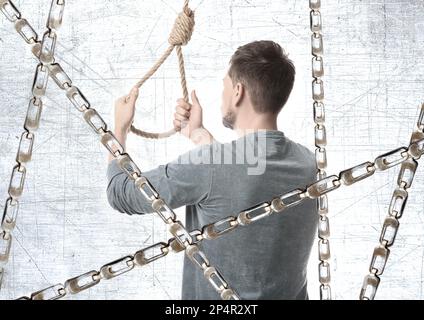 Homme avec une corde et des chaînes métalliques, vue arrière Banque D'Images
