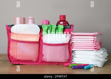 Différents tampons menstruels, tampons et produits de soin de la peau sur une table en bois Banque D'Images