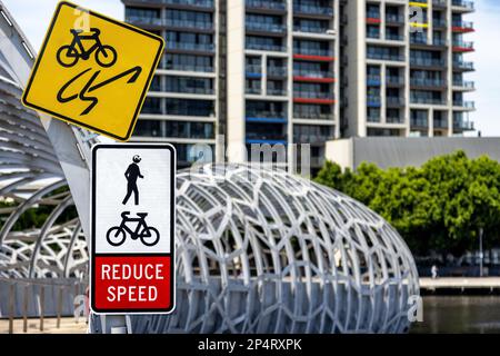 Pont webb de Melbourne traversant la Yarra River, avec des instructions pour les cyclistes de réduire la vitesse et d'être au courant des piétons. Quelqu'un a ajouté un oeil de googly Banque D'Images