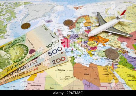 Tirana, Albanie - 09 juillet 2019: Composition d'une carte du monde centrée sur l'Albanie avec sur elle, quelques billets et pièces de lek albanais ainsi qu'un jouet Banque D'Images