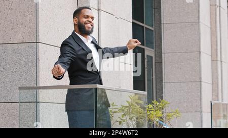 Joyeux drôle gai Africain ethnique américain employé ayant amusant entrepreneur homme d'affaires sur le balcon de bureau dansant célébrer les affaires Banque D'Images