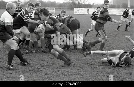 1980s, match de rugby amateur, d'un hommage, un joueur de rugby masculin, la demi-balle, s'en va avec le ballon en main, Angleterre, Royaume-Uni. Banque D'Images