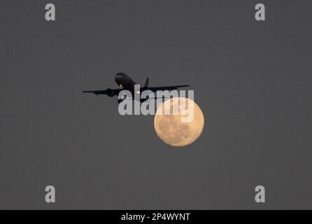 New Delhi, Inde. 6th mars 2023. Un avion est vu avec la pleine lune derrière à New Delhi, Inde, 6 mars 2023. Crédit : Javed Dar/Xinhua/Alay Live News Banque D'Images